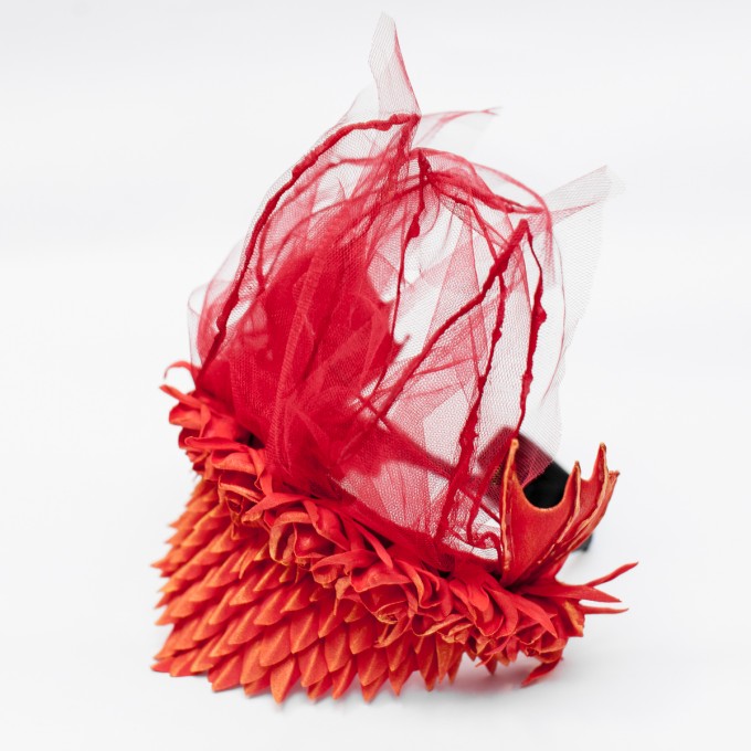 Red dragon headress with wings, decorated roses, scales, veiling.